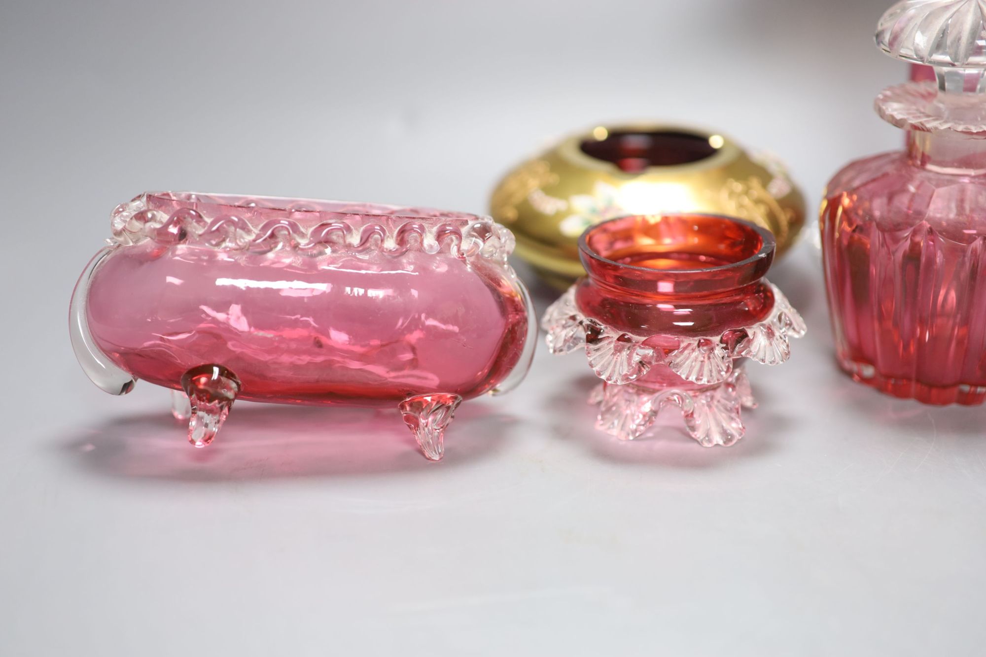 Six pieces of cranberry glass and a later bohemian ashtray, tallest 21cm